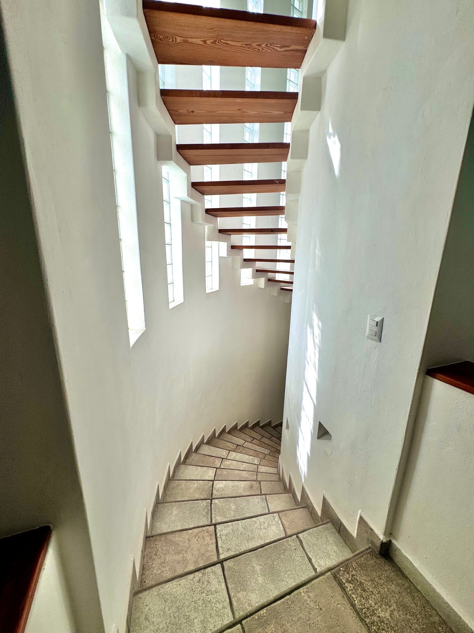 Luxurious interior of Casa 51 featuring grand staircase and triple-height ceilings